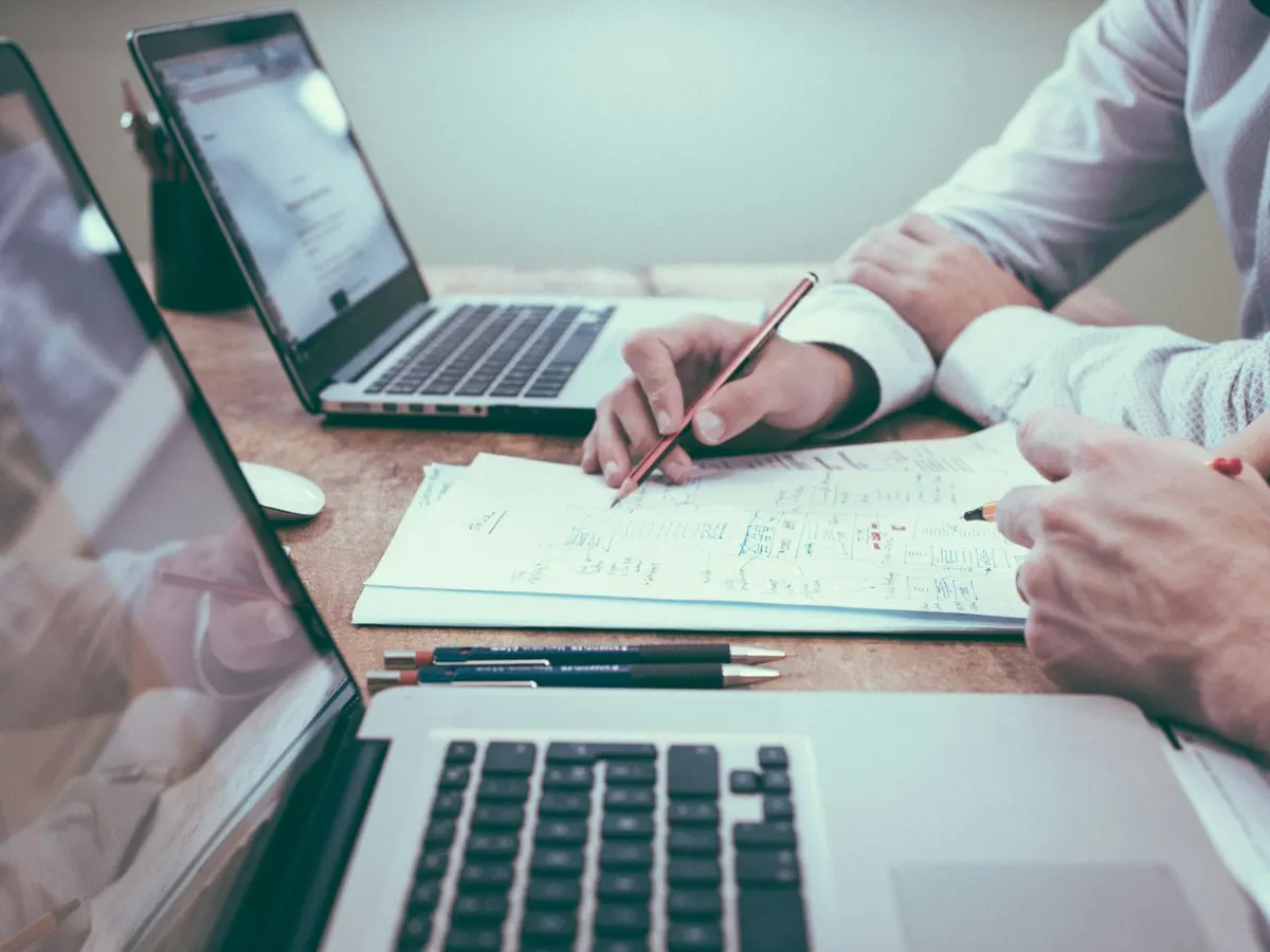 Overleg aan een bureau met laptop en papieren